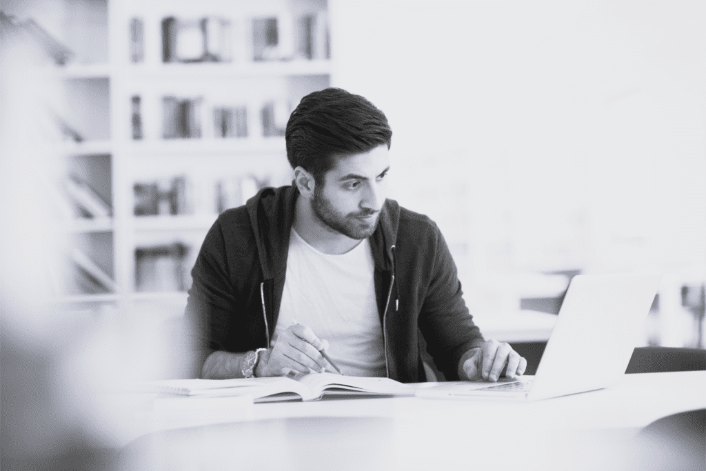 Multietnisk mand studerer på bærbar