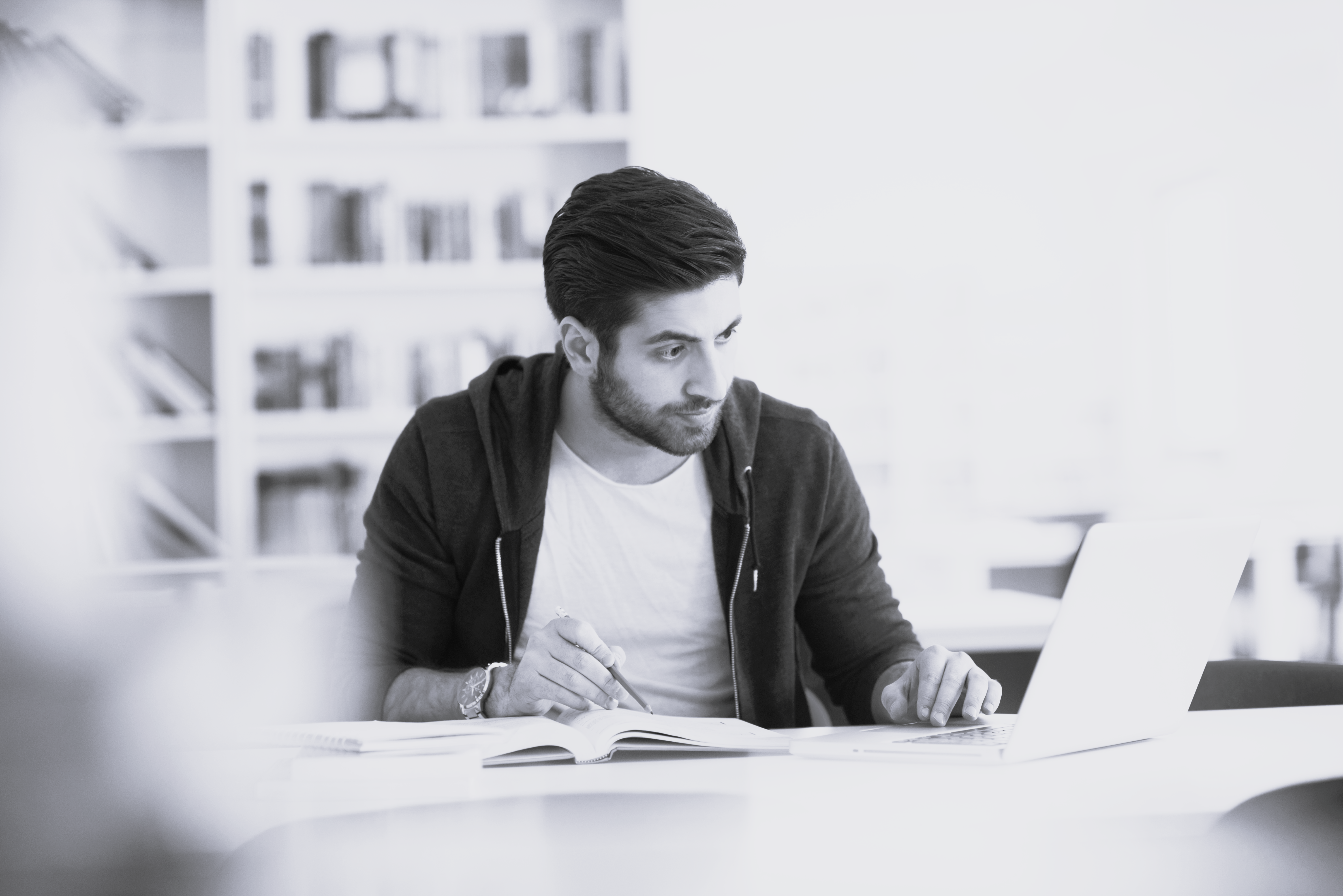 Multietnisk mand studerer på bærbar