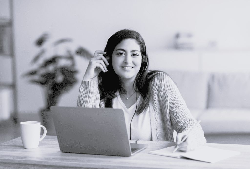 Ung multietnisk kvinde med hovedtelefoner på arbejder