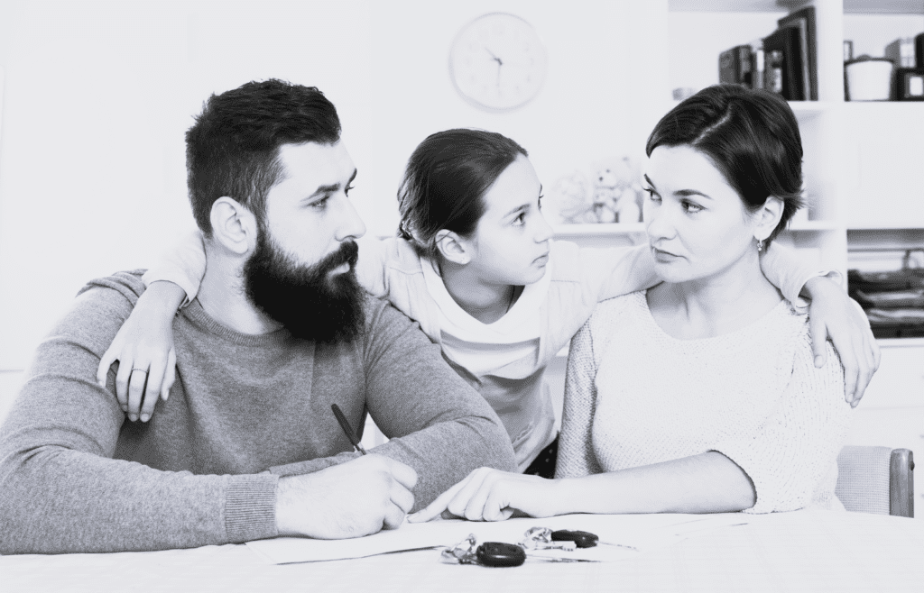 Forældre argumenterer med deres barn i midten og er nedtrykte