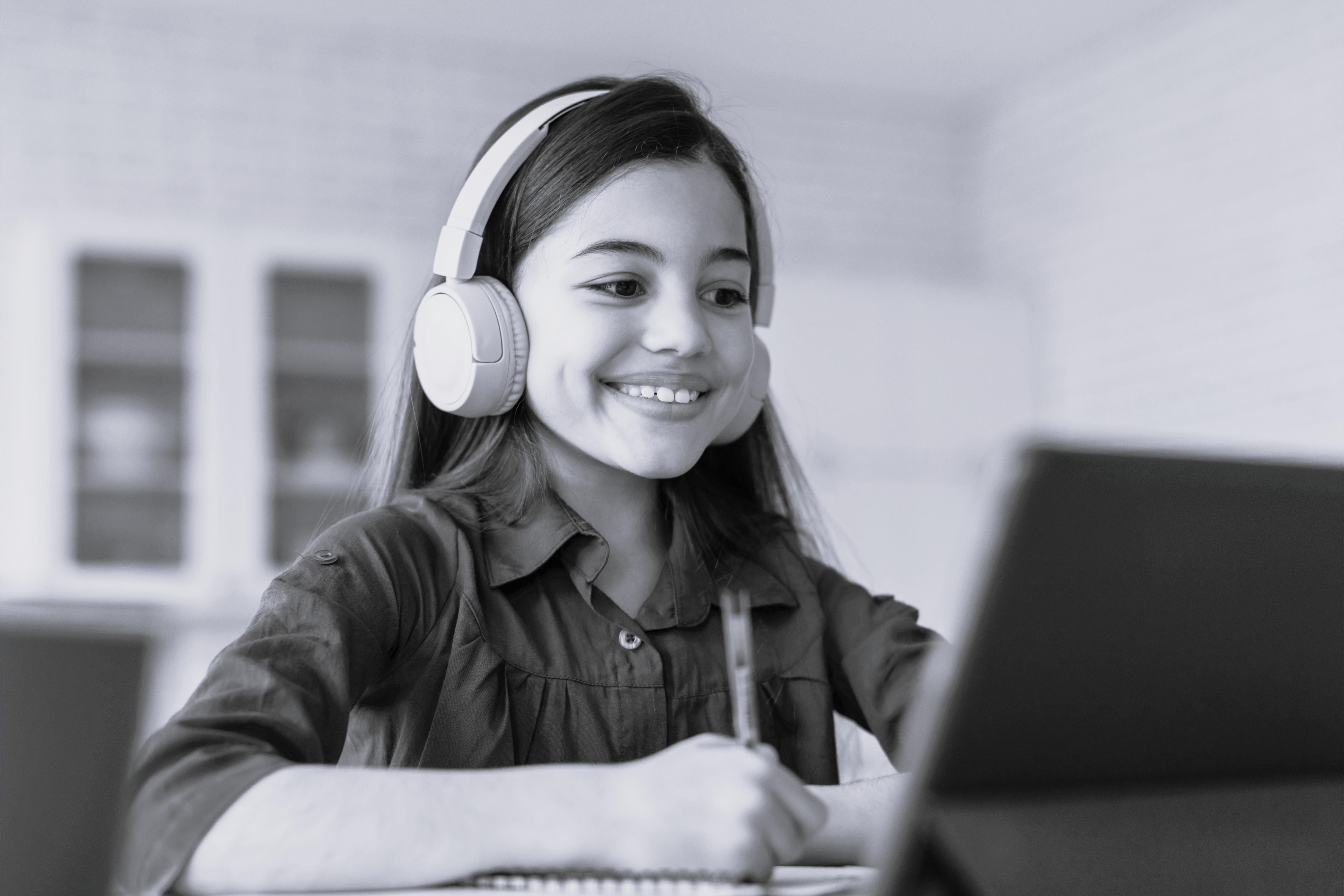 Ung pige studerer på bærbar og smiler